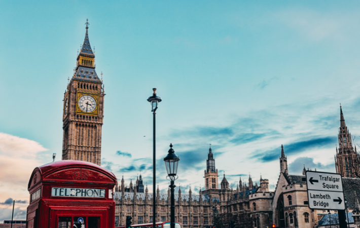 Imagem de Londres com o Big Ben ao fundo e o topo de uma cabine telefônica vermelha a frente.
